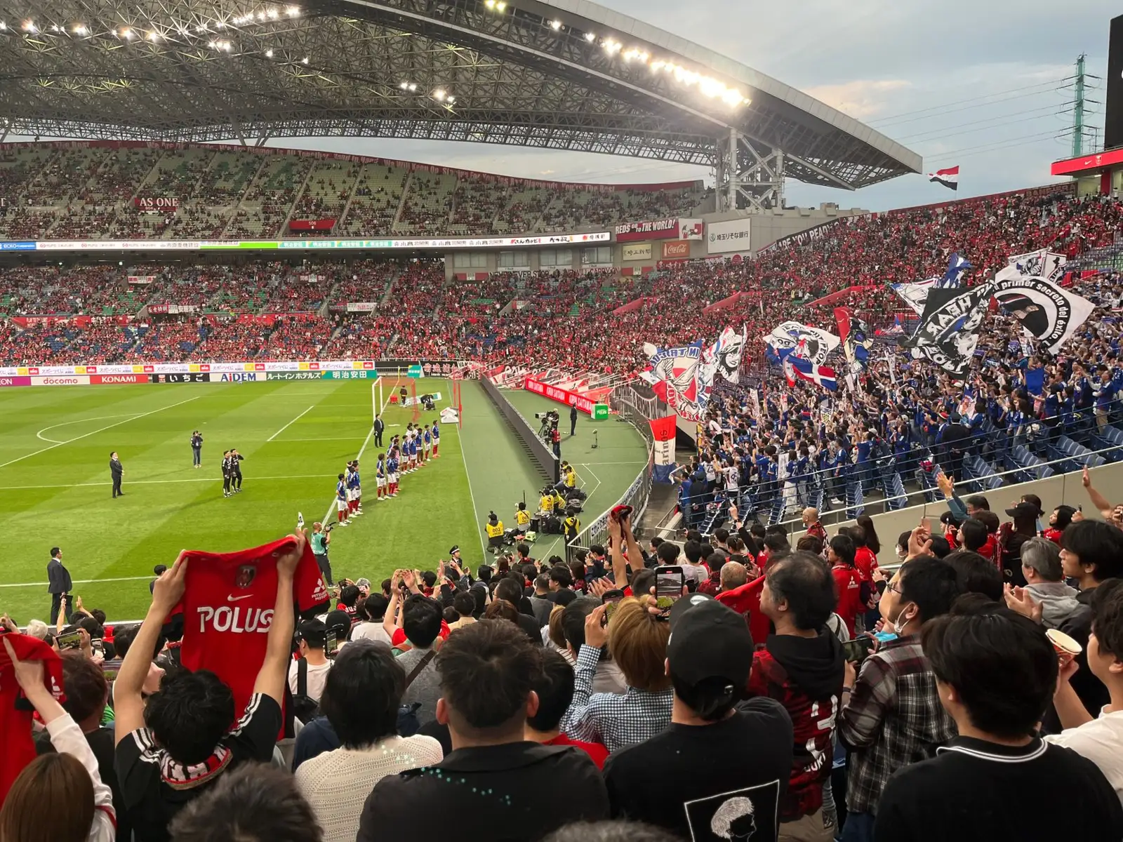 두 팀 팬들이 뒤섞인 만원 관중석 앞에서 킥오프를 기다리는 축구 경기장 전경