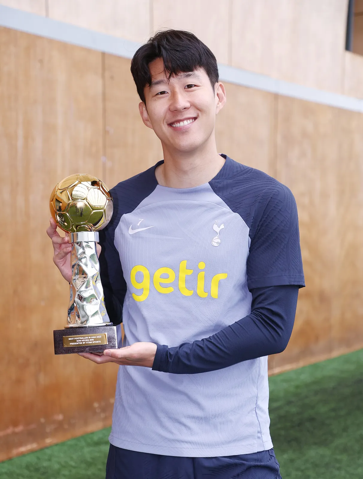 라커룸 벤치에 앉아 정면을 응시하는 손흥민의 차분한 옆모습