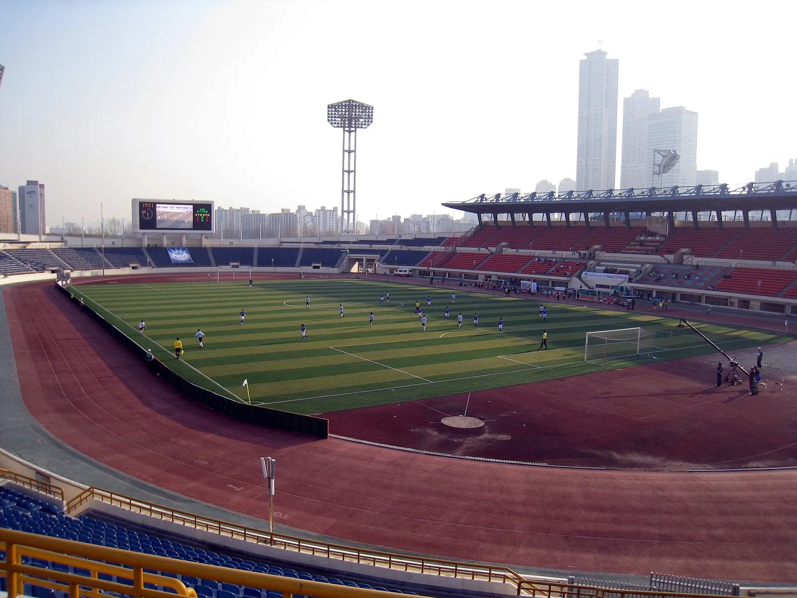 경기장 전광판에 득점자 이름과 4-3 스코어가 표시된 야간 축구 경기장 전경