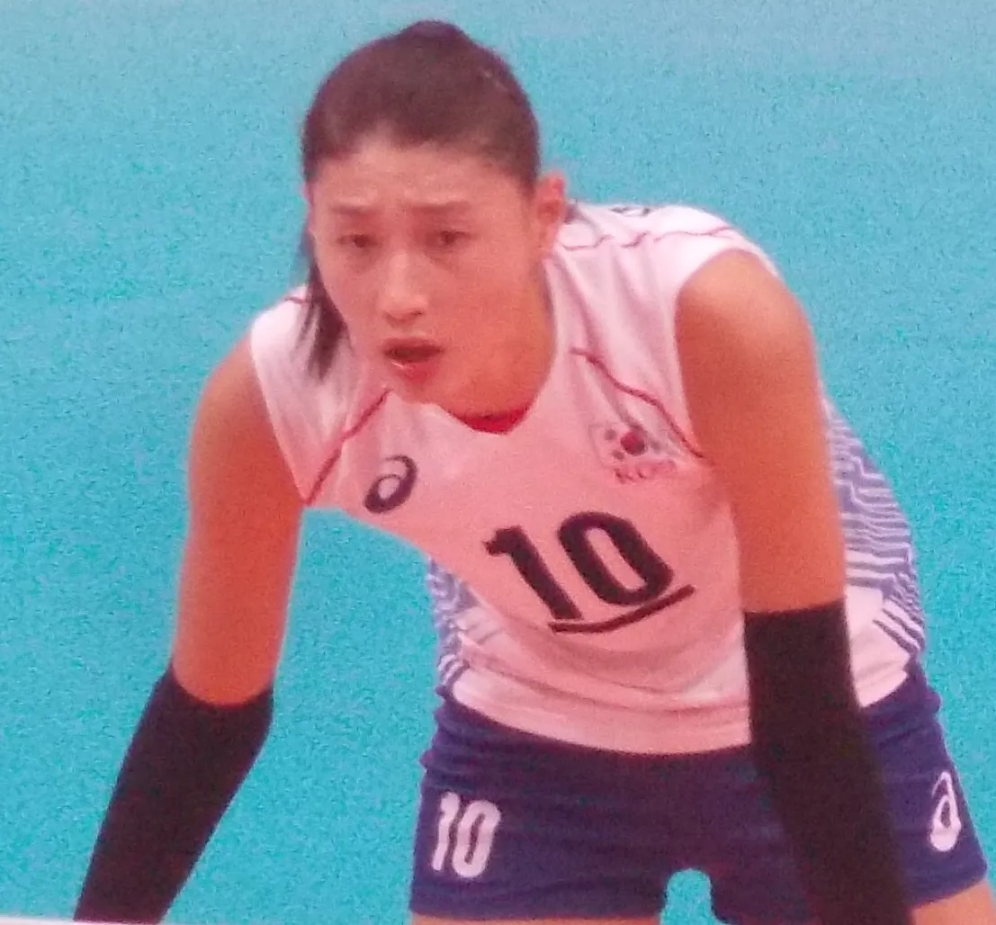 배구 코트 옆에서 이야기를 나누는 사람들의 뒷모습